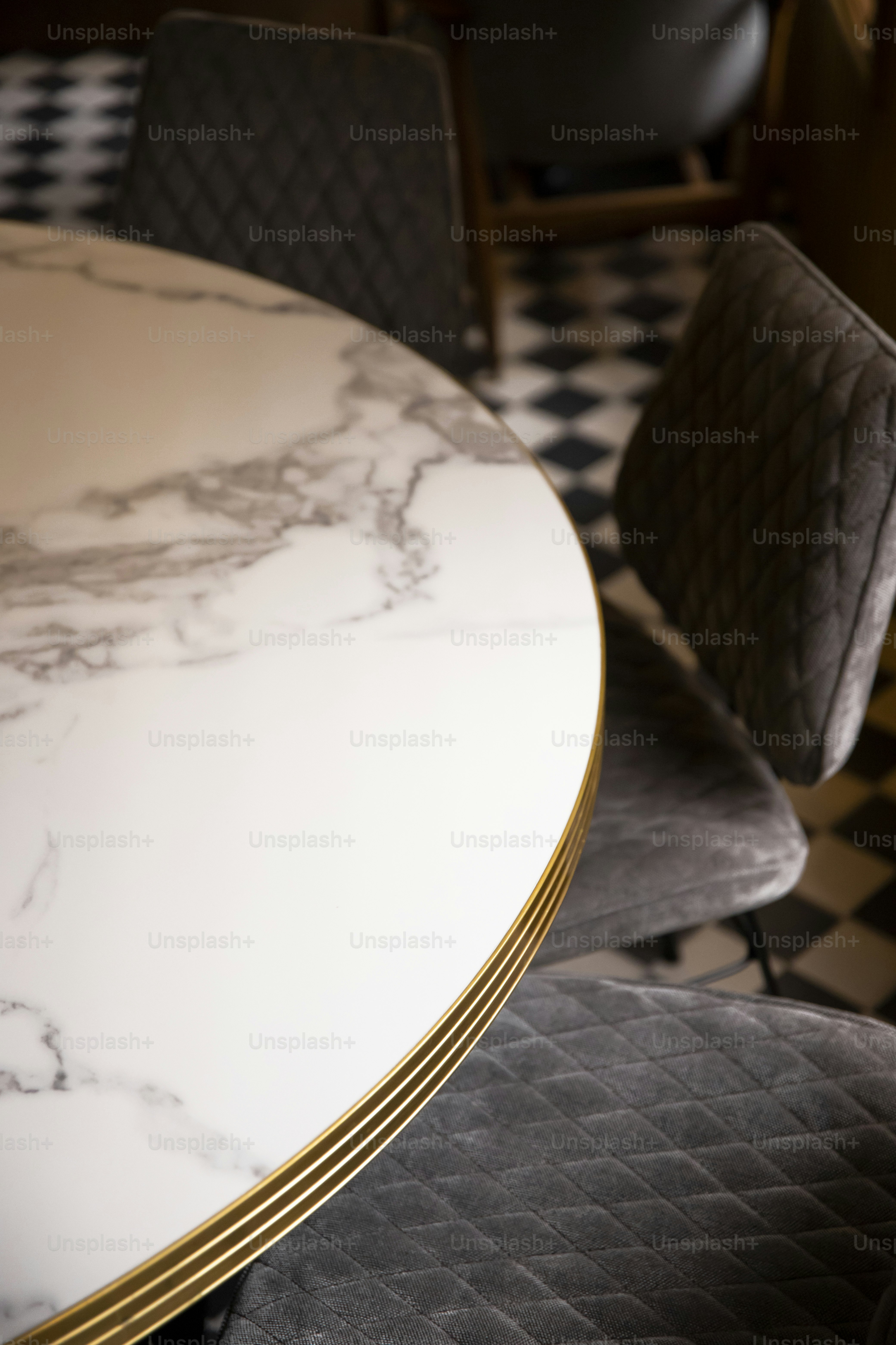 a table with a white marble top and a black and white checkered floor